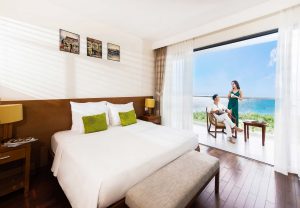 2 người đứng tại ban công phòng nghỉ cao cấp view biển