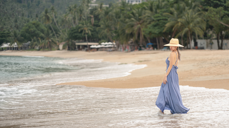 cô gái mặc váy maxi đi dạo trên bãi biển